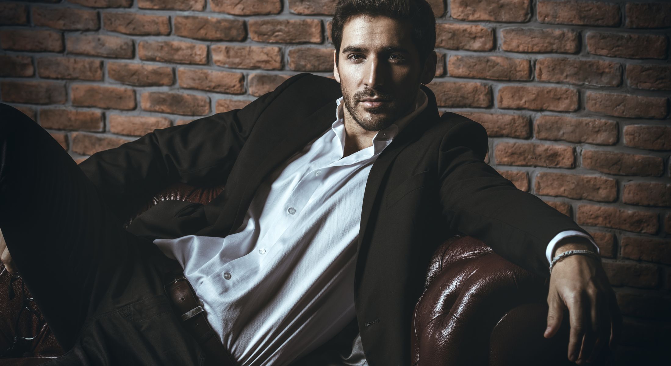 male enhancement model sitting on a leather chair